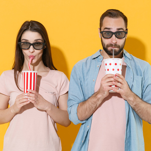 Foto de una mujer y  un hombre con gafas de sol tomando una bebida