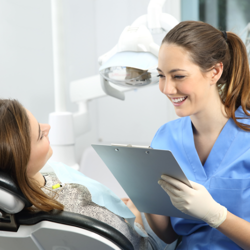 Dentista atendiendo a paciente en consultorio dental.