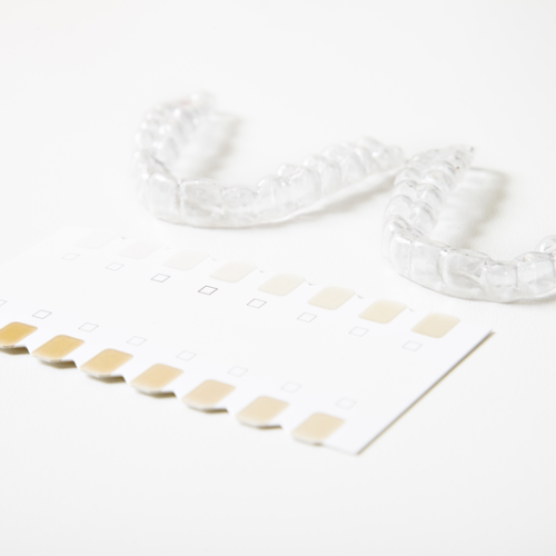 Guía de tonos dentales y férula dental sobre fondo blanco.