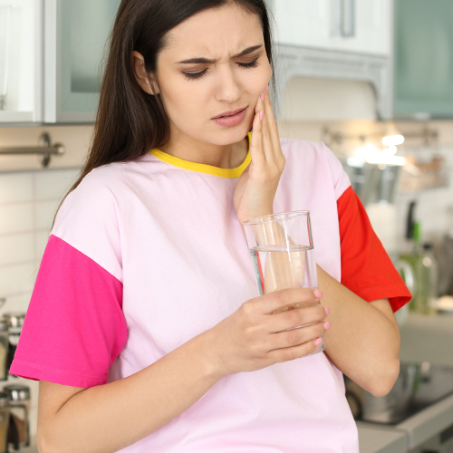 joven mujer sensible dientes vidrio frío
